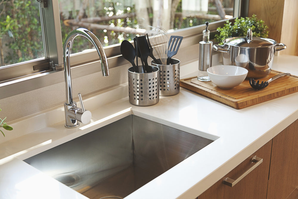 A white kitchen bench featuring a Cefito stainless steel sink and silver mixer tap.